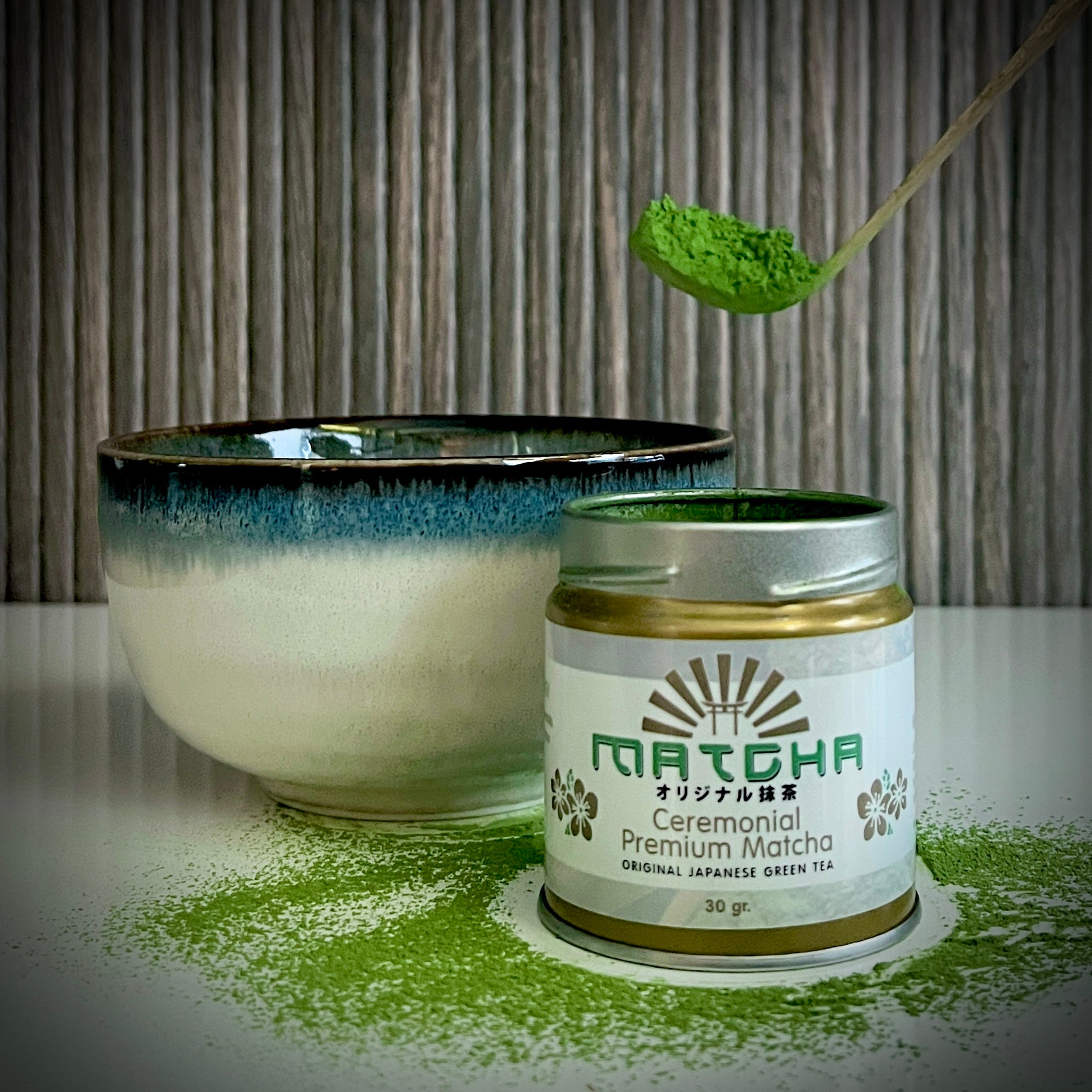 Goudkleurig open potje 'Ceremonial Supreme Matcha' (30 gram)  van The Matcha Man, een lichtblauwe matcha kom en een bamboelepel met matcha