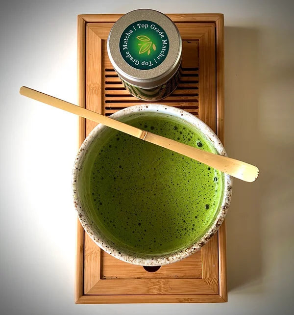 Gevulde matcha kom met  matcha, een bamboelepel en een potje 'Ceremonial Top Grade Matcha' van The Matcha Man (30 gram) op  een serveerblaadje.